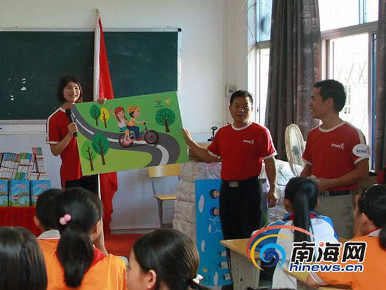安利志愿者拿著KT畫板形象地告訴小學生自行車安全5守則
