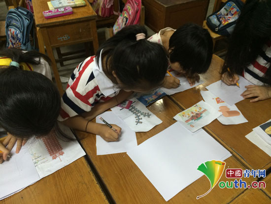 公益課堂上，鄭州大學(xué)支教團(tuán)成員指導(dǎo)學(xué)生描繪河南景觀。
