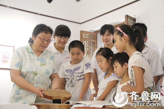 東昌府區(qū)年畫社社長(zhǎng)徐秀貞向同學(xué)們講解年畫制作過程。