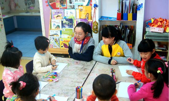 工美附中學(xué)生在輔導(dǎo)幼兒園小朋友學(xué)習(xí)繪畫