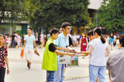 昨日，江北區觀音橋步行街，不少市民購買報紙，支持貧困學生。