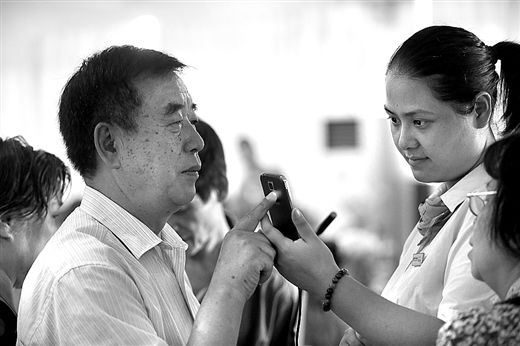 工作人員在教老人使用手機(jī)
