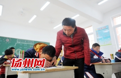 課堂上,單成學正在教一名學生畫畫。 課堂上,單成學正在教一名學生畫畫。