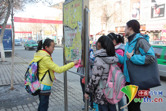 對外經濟貿易大學支教團成員黃曉鳳帶領少先隊員清理公交亭。 對外經濟貿易大學支教團成員黃曉鳳帶領少先隊員清理公交亭。
