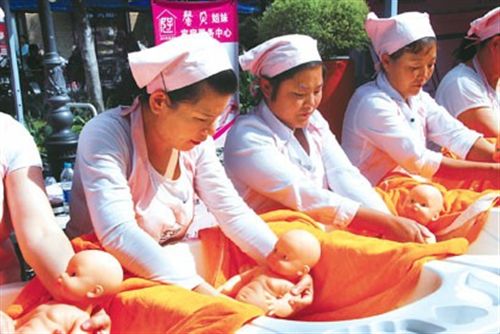 家政服務人員現場演示如何給嬰兒洗澡。