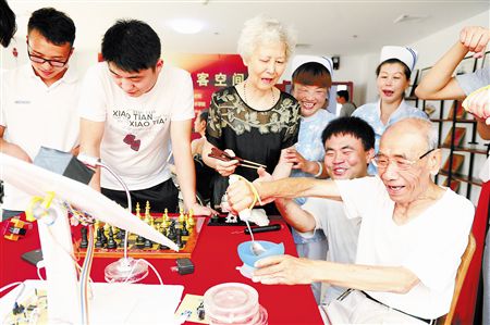 老人在體驗助老餐具。本報記者