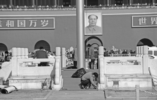 1日,天安門廣場上工作人員認真鋪設紅地毯,為兩會期間升國旗儀式做好準備。