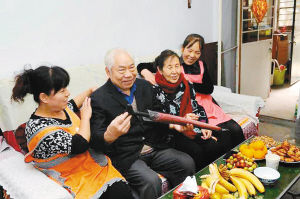 昨日,養老護理員在全國勞模周福英老人(右二)家中,為她和老伴做推拿按摩。