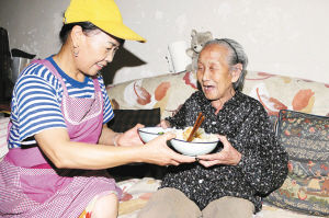 87歲的楊桂蘭老人看到王淑珠冒著酷暑送來午餐,動情地說:“你就是我的親閨女!”