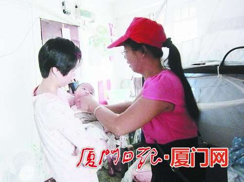 李麗上門看望剛生完寶寶的社區姐妹。（陳明芳 攝）